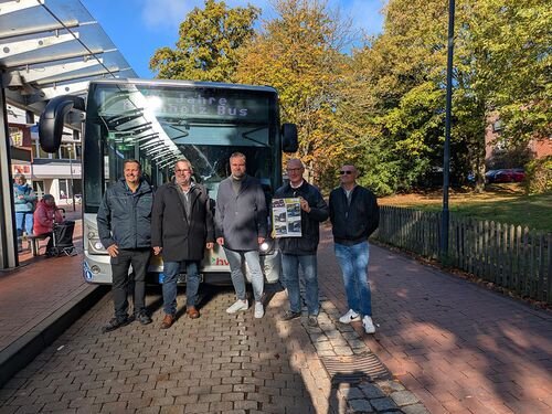 Fünf Männer stehen vor einem Bus